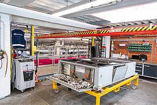 KBK crane transports air-conditioning units in an industrial environment